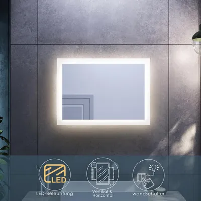 A modern bathroom mirror with LED lighting mounted on a textured gray tiled wall.