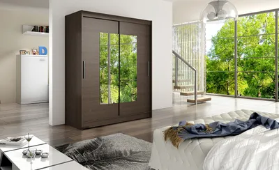 A bedroom scene with a large wardrobe, bed, and a window overlooking trees.
