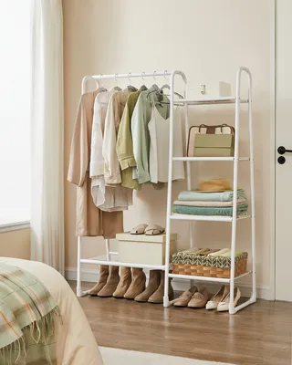 A white clothing rack with clothes and accessories displayed in a room.