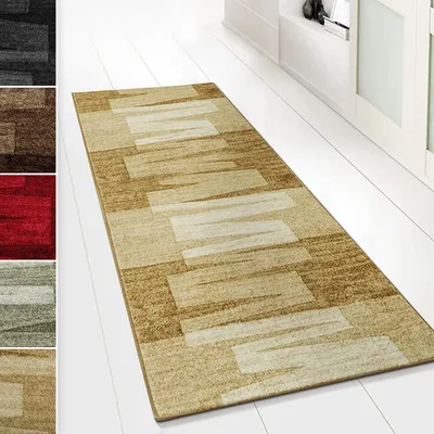 A runner rug with a geometric pattern is displayed on a white wooden floor.