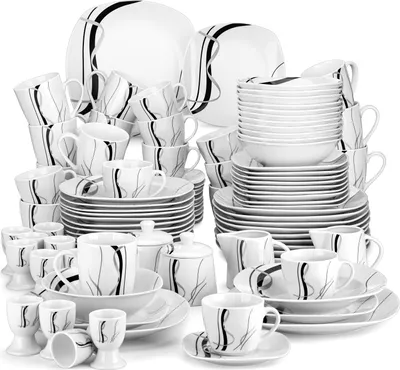 A collection of white porcelain dinnerware and drinkware with black and gray abstract line designs, arranged in a studio setting against a white background.