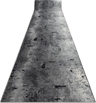 A runner rug with a concrete-like pattern, shown from a slightly elevated angle, with the top end curving upwards.