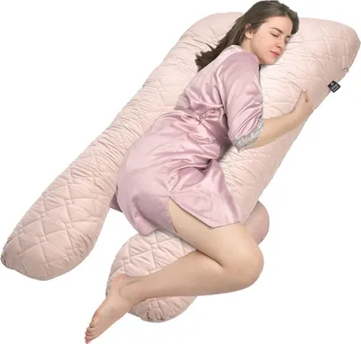 A woman sleeping on a large body pillow.