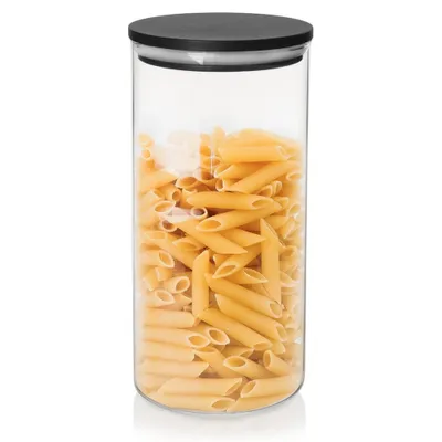 A clear glass jar filled with penne pasta, with a black lid.
