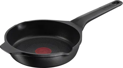 A black frying pan with a red heat indicator in the center, shown from a side angle on a white background.