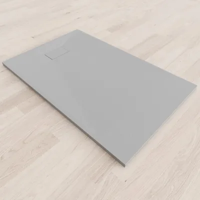 A grey shower tray on a light wood floor.