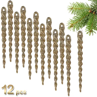 A collection of gold glittery icicle ornaments arranged in a cascading pattern, with a hint of a green pine branch in the upper right corner.