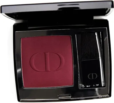 A close-up, top-down view of an open Dior Rouge Blush compact with the blush and applicator visible.