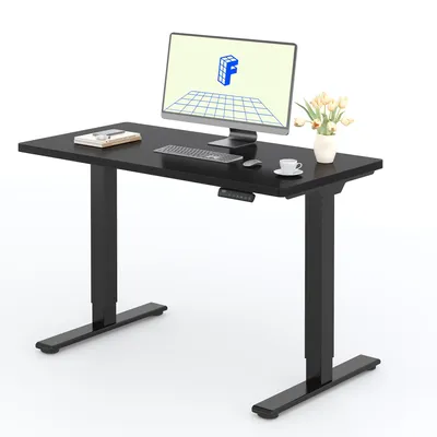 A black adjustable height desk with a computer monitor, keyboard, mouse, and a small vase of flowers.
