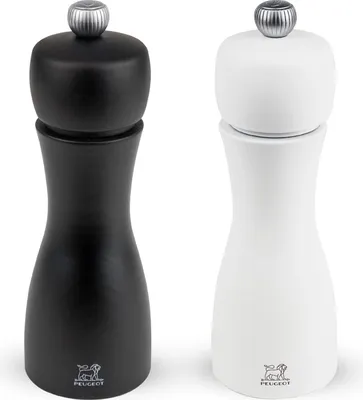 A pair of PEUGEOT pepper and salt mills in black and white.