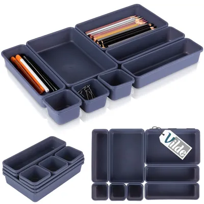 A set of modular drawer organizers with various compartments, some containing office supplies like pencils and paper clips.