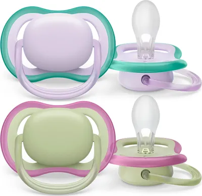 Two pairs of baby pacifiers, one purple and teal, the other green and pink, are shown against a white background.