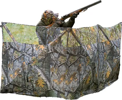 A person is using a camouflage hunting blind.