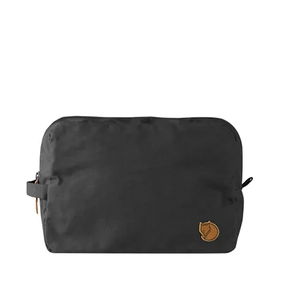 A black toiletry bag with a brown logo is shown against a white background.
