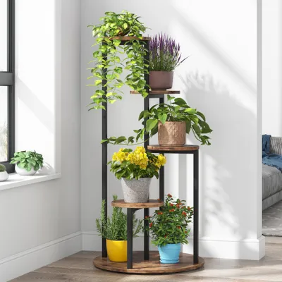 A multi-tiered plant stand filled with various potted plants is placed in a corner of a room near a window.
