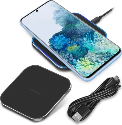 A smartphone is wirelessly charging on a charging pad, with a charging cable nearby.