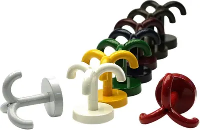 A collection of multi-pronged hooks in various colors arranged in a diagonal line against a white background, with a white hook in the foreground on the left.