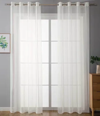 Two white sheer curtains hanging on a window rod in front of a window.