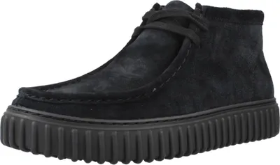 A studio shot of a black suede boot.