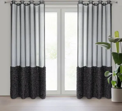 Two black and gray curtains hanging in front of a window.