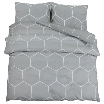 A neatly folded grey duvet cover and two pillowcases with a white hexagonal pattern, laid out on a white background.