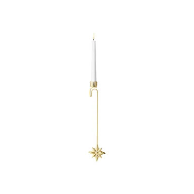 A single gold-plated star-shaped candleholder with a white candle.