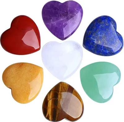 A collection of seven heart-shaped polished stones arranged in a circular pattern.