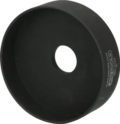 A black metal adapter with a hole in the center, placed on a white background.