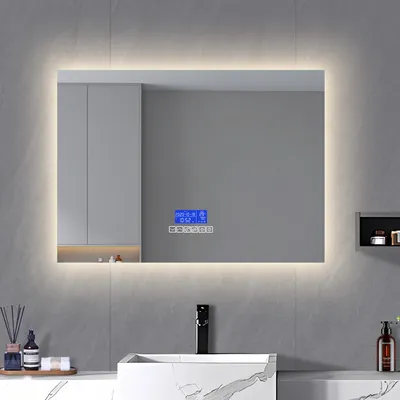 A modern bathroom vanity with a large illuminated mirror above it.