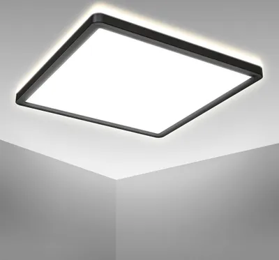 A square LED panel light is mounted on a white ceiling, casting a bright, neutral white light.