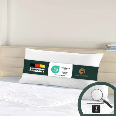 A white pillow on a bed.