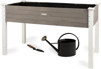 A raised garden bed with gardening tools.