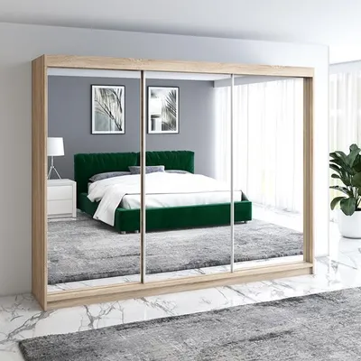 A bedroom with a large wardrobe with mirrored doors reflecting a bed and bedside table.