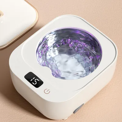 A close-up shot of a white facial steamer with water and purple light inside.