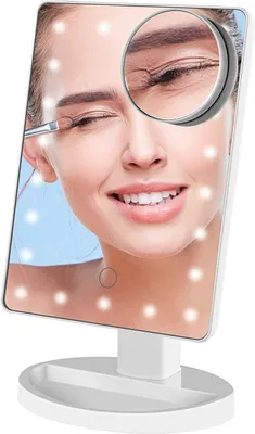 A woman is applying makeup using a lighted makeup mirror. The mirror has LED lights around the edge and a magnifying section showing a close-up of the eye area.