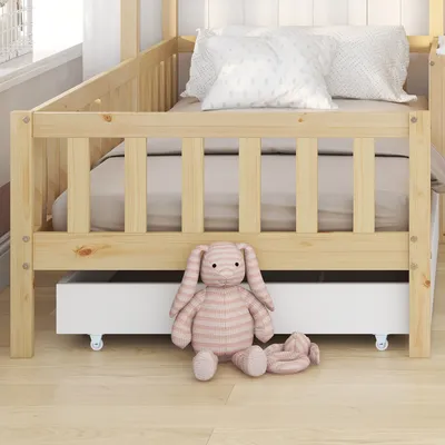 A child's bed with a drawer and stuffed animals.