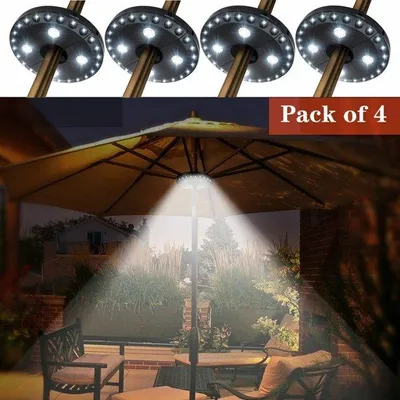 An outdoor patio scene at night, illuminated by umbrella lights.