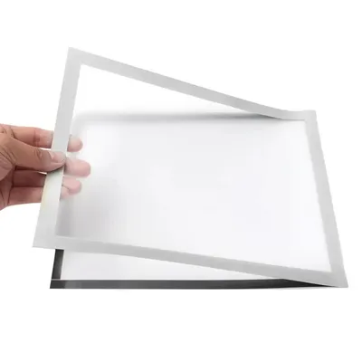 A hand holding a magnetic photo frame over another frame.