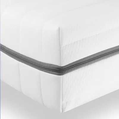 A close-up view of a white mattress with a gray zipper detail.