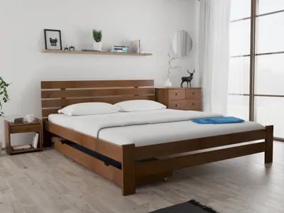 A wooden bed frame with white bedding in a bedroom setting.