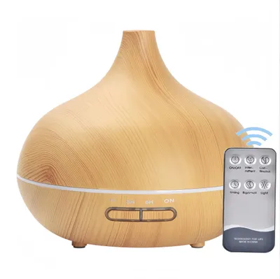 A humidifier/diffuser with a remote control on a white background.