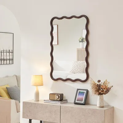 A living room scene with a mirror on the wall above a console table.