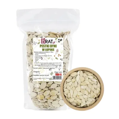 A bag of pumpkin seeds in their shells next to a wooden bowl filled with pumpkin seeds.