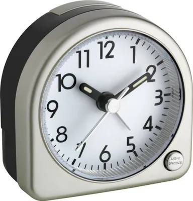 A close-up studio shot of a silver and black analog alarm clock against a white background.
