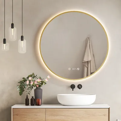 A modern bathroom vanity with a round LED mirror, sink, and decorative items.