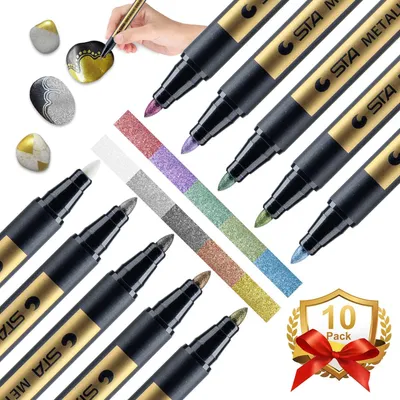 A collection of metallic marker pens and decorated stones, with a hand demonstrating their use.
