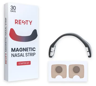 Face avant de la boîte du kit de départ Resty Magnetic avec le clip noir réutilisable et une paire de languettes beiges sur leur film protecteur, sur fond blanc.