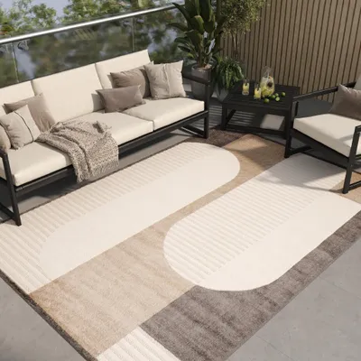 An outdoor patio setting with a sofa, armchair, coffee table, and a rug.