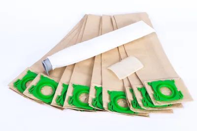 A collection of vacuum cleaner bags and filters laid out on a white background.