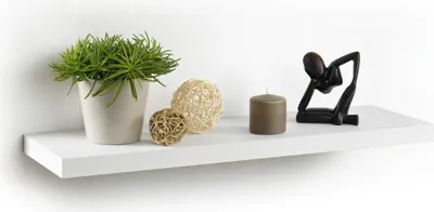 A white floating shelf with decorative items.